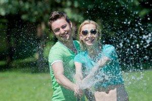 couple playing outdoors sprinkler adults get outside fresh perspective landscapes blue mountains