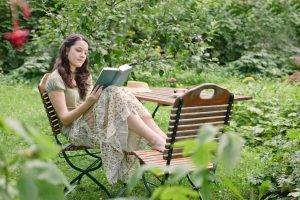 woman reading book in backyard