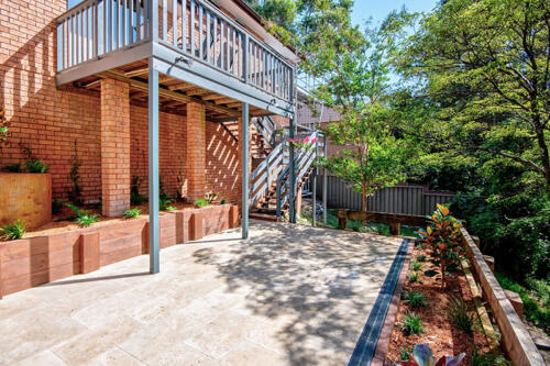 Timber balcony above large paved area 