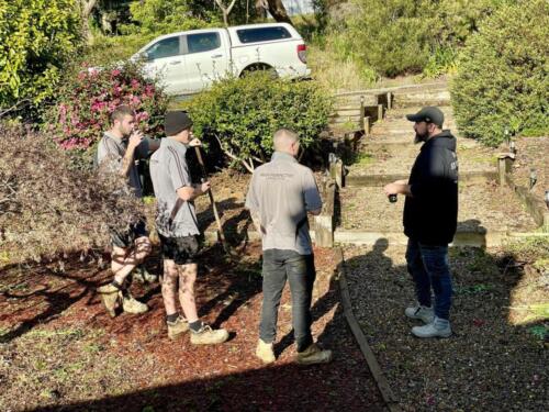 Team meeting assessing garden for landscaping preparation