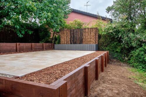 Timber retaining wall for paved area
